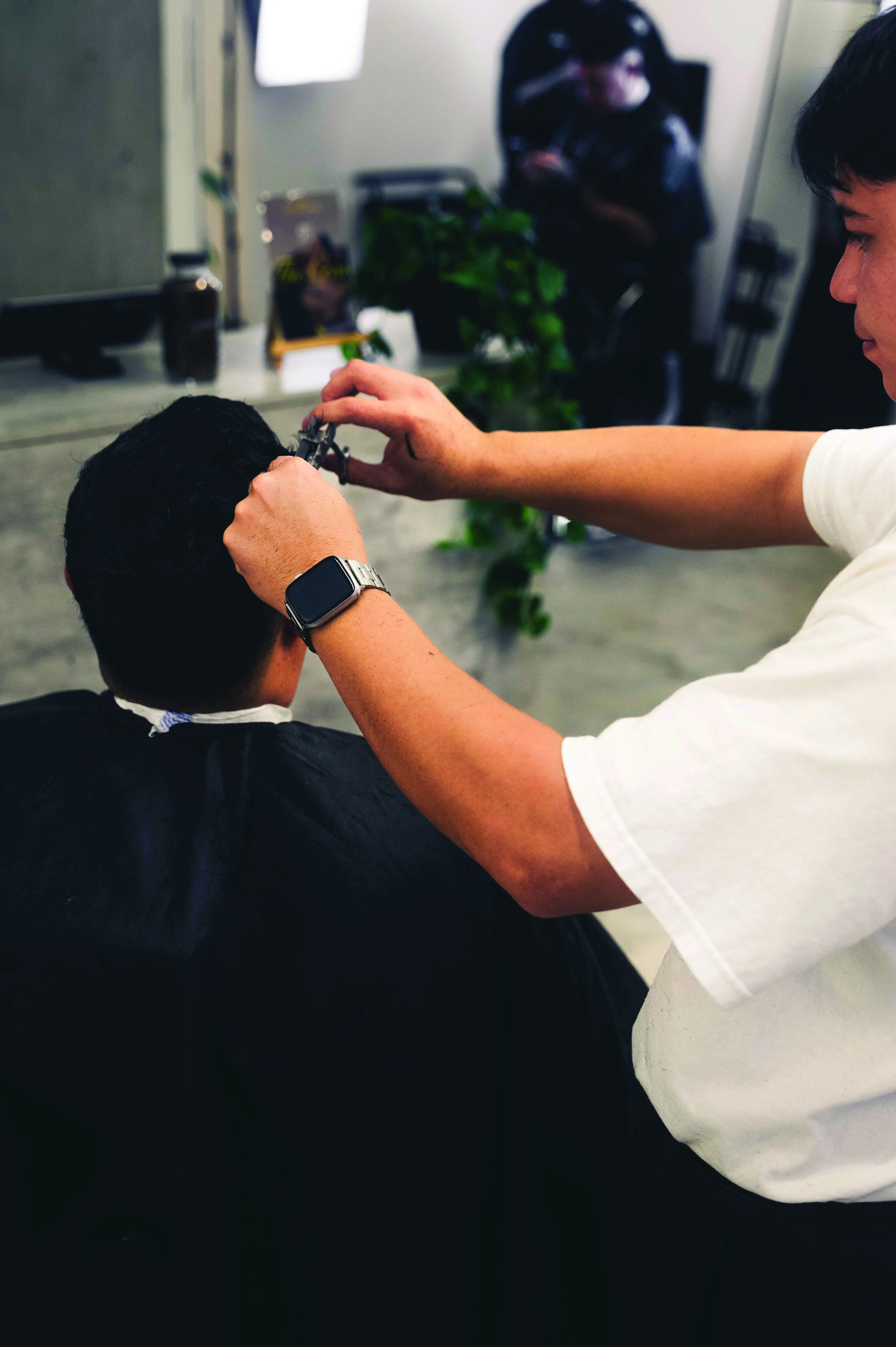 Detalle de manos y máquina cortando cabello